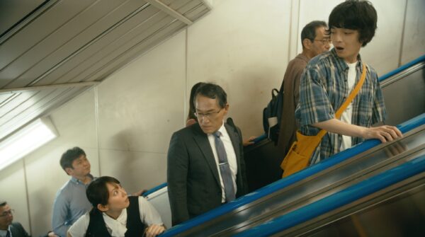 NHK夜ドラ『ひらやすみ』第5回より。急いでいるよもぎさんと、エスカレーターで立ち止まるヒロトくん